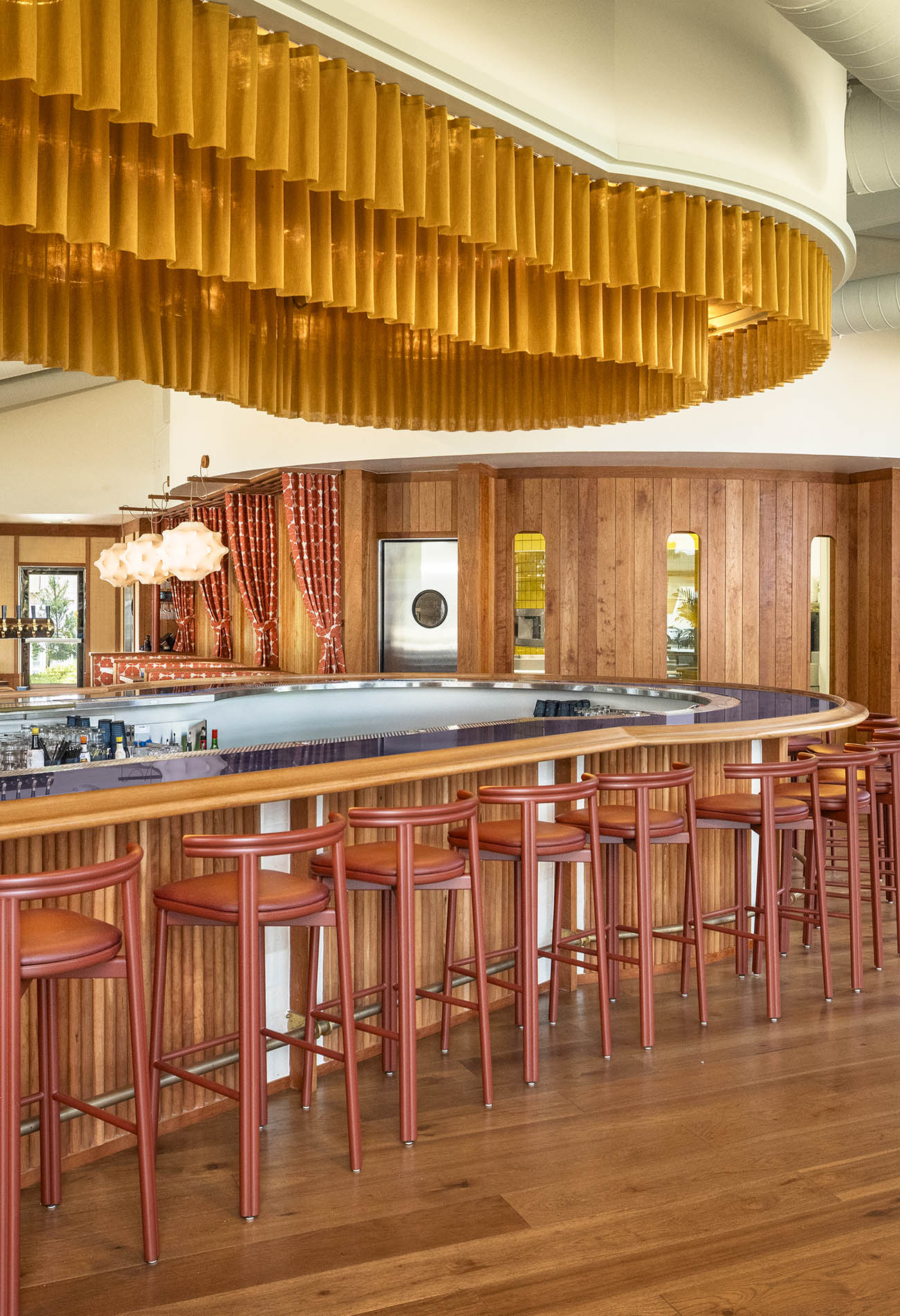 Interior of Lana, an American restaurant and bar located in Solana Beach, California. The design by Workind Studio utilizes warm tones and striking architectural elements.