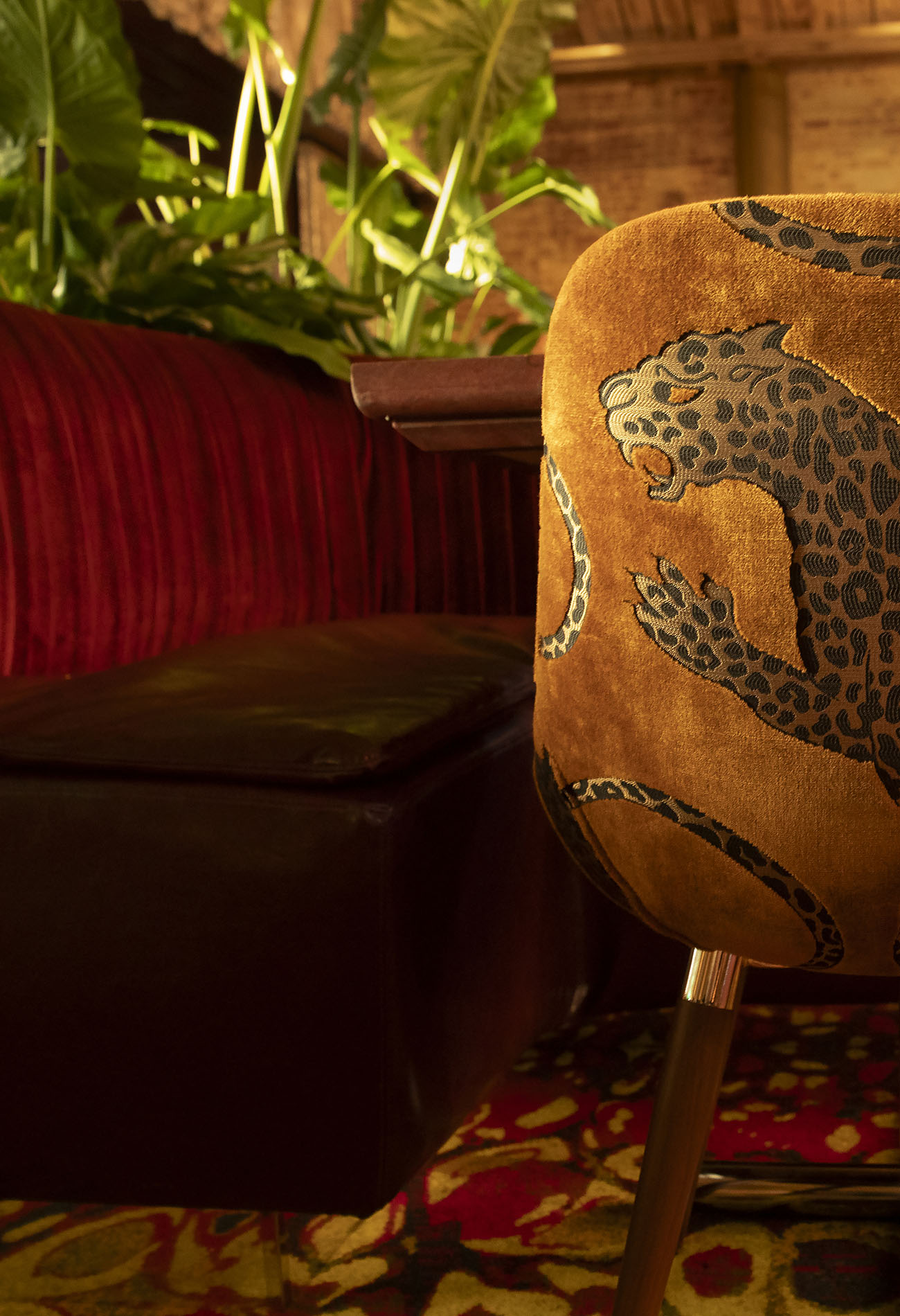 Workind Studio custom furniture for French steakhouse LE COQ in La Jolla, California, The banquette is upholstered in burgundy velvet and the chair is upholstered in Catherine Martin's "Panthera Gold", a velvet fabric from the Royal Managerie collection for Mokum Textiles.